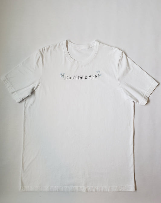 A white T laid flat. "Don't be a dick" is hand embroidered in black with two small hydrangea blossom branches on either side of the text.